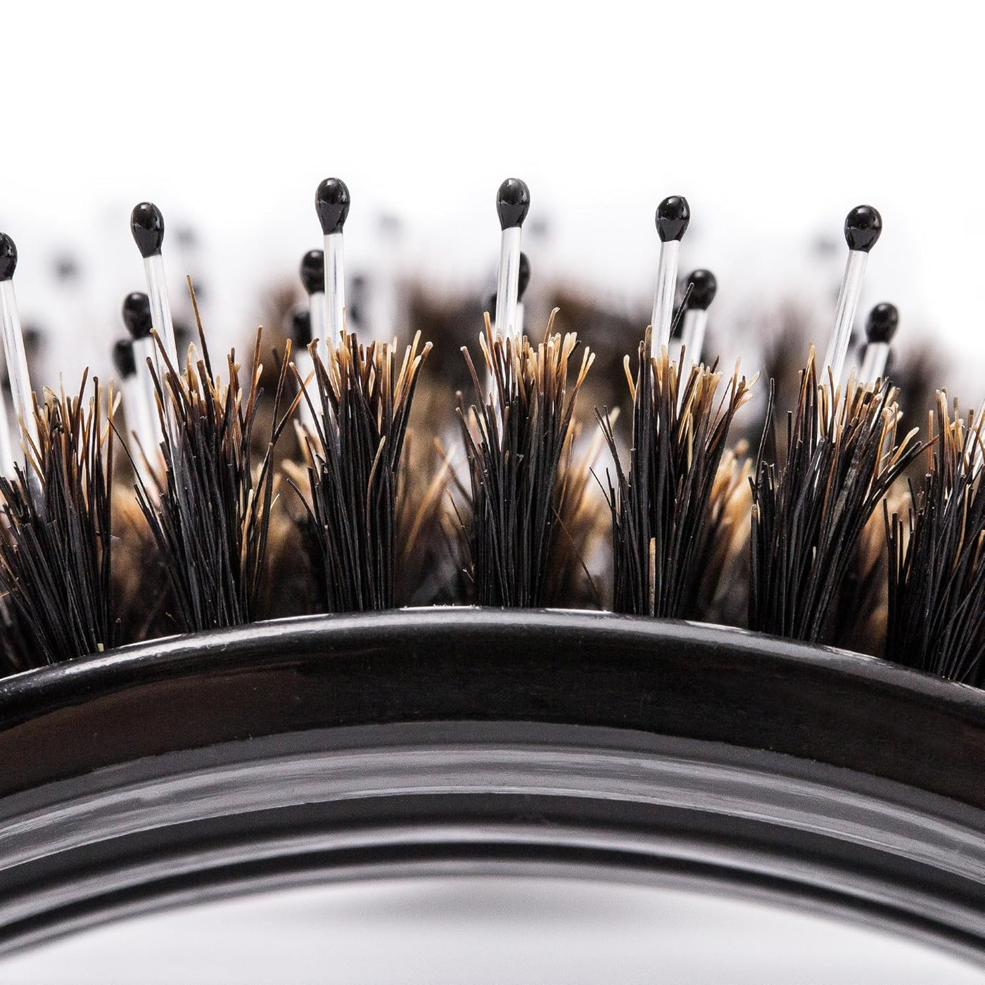 Close-up of a hairbrush with bristles showing signs of wear on a white background
