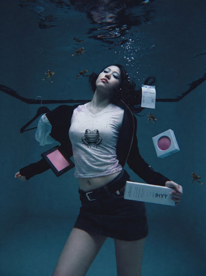 Person underwater with floating objects and clothing items