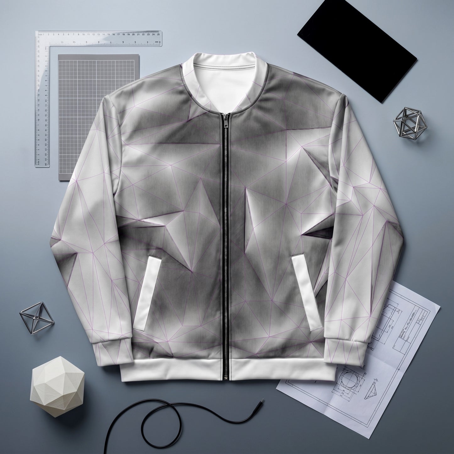 Gray geometric-patterned jacket on a gray background with design tools.