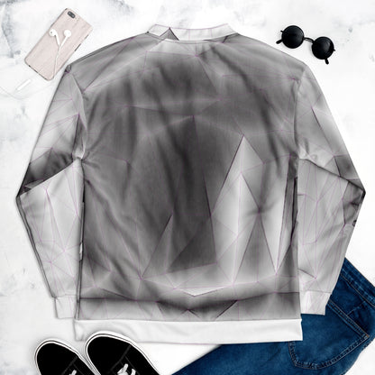 Geometric patterned shirt on a marble surface with phone, sunglasses, and jeans.