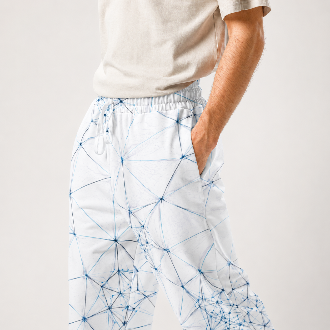 Person wearing white ANSO pants with blue geometric pattern on a plain background