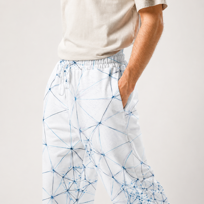 Person wearing white ANSO pants with blue geometric pattern on a plain background