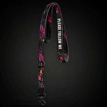 Colorful dog leash with 'PLEASE FOLLOW ME' text on a black background