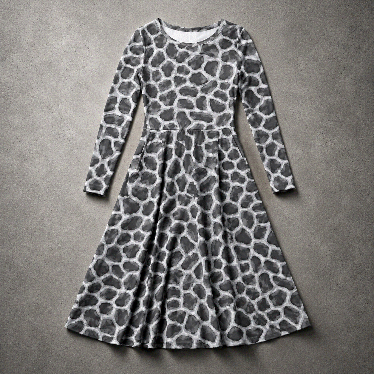 Flat-lay view of the ANSO Cellular Mesh Midi Dress on a textured grey surface, showing the full long-sleeve shape, fitted waist seam, flared skirt, and all-over cellular mesh print.