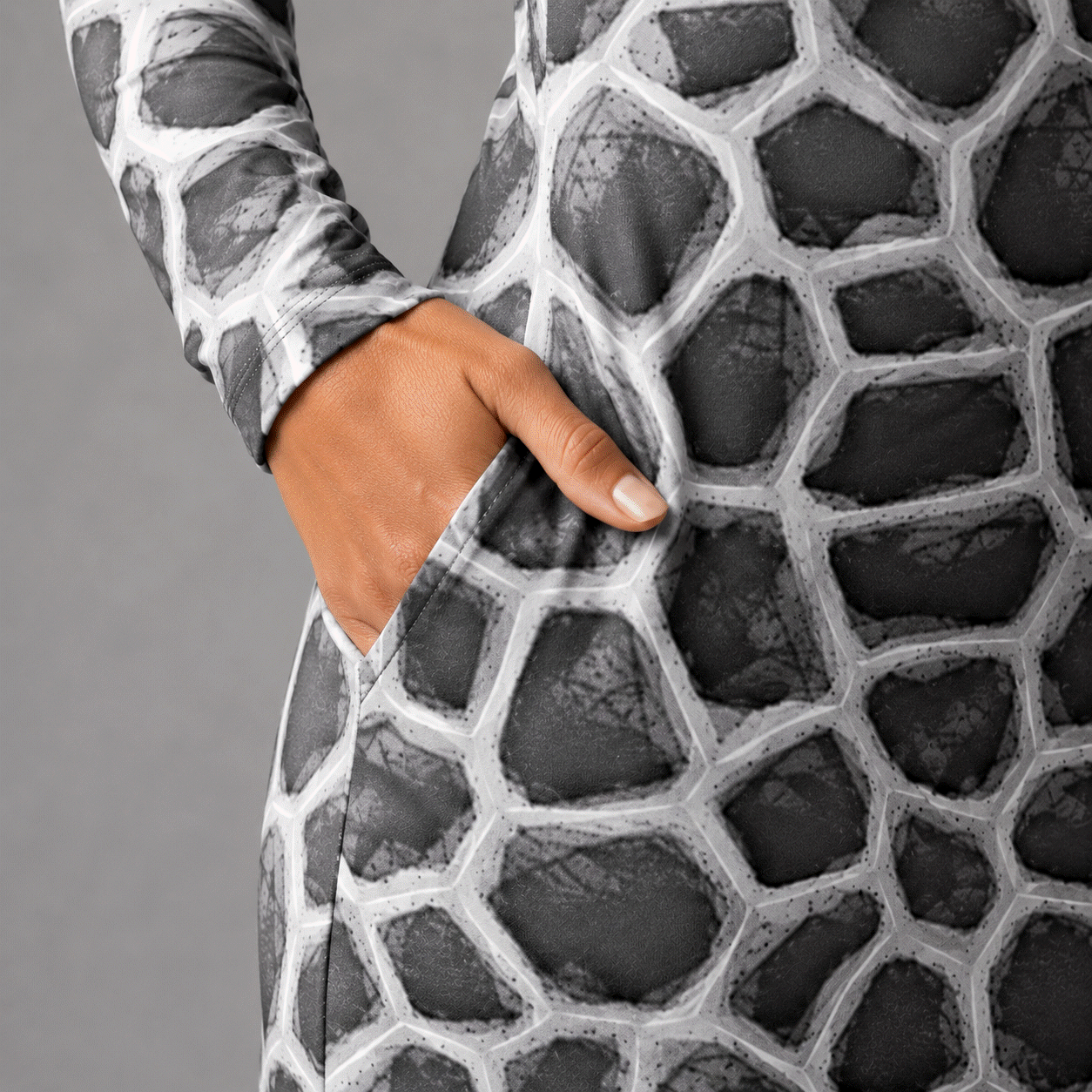 Close-up of the ANSO Cellular Mesh Midi Dress pocket with a hand placed inside, highlighting the side-pocket construction, stretch fabric surface, and grey cellular mesh print.