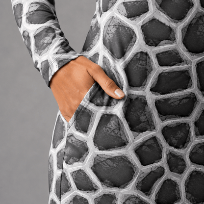 Close-up of the ANSO Cellular Mesh Midi Dress pocket with a hand placed inside, highlighting the side-pocket construction, stretch fabric surface, and grey cellular mesh print.