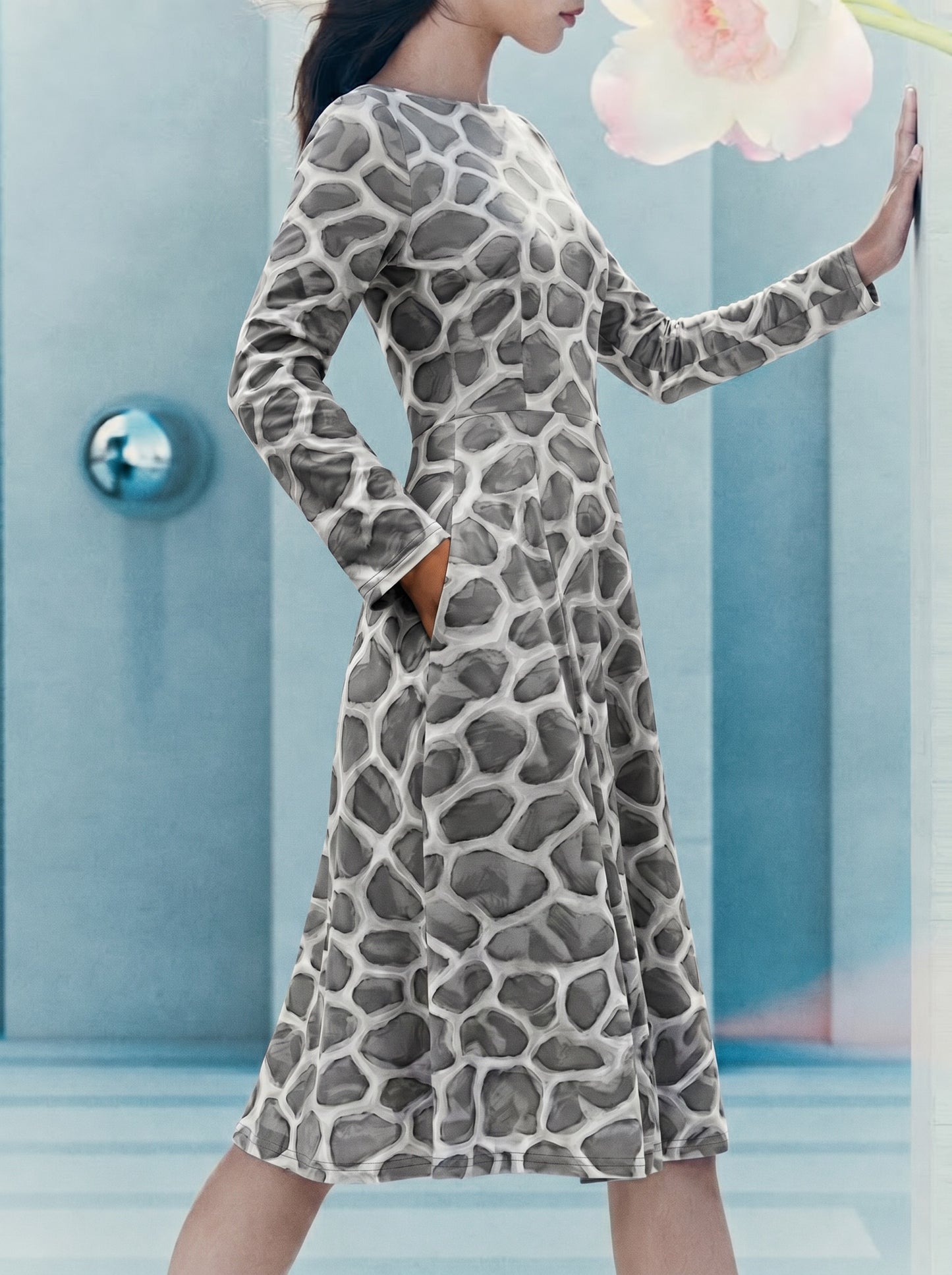 Side-view editorial image of a model wearing the ANSO Cellular Mesh Midi Dress in a soft blue interior, showing the pocket, fitted waist, long sleeves, and flowing midi-length skirt.