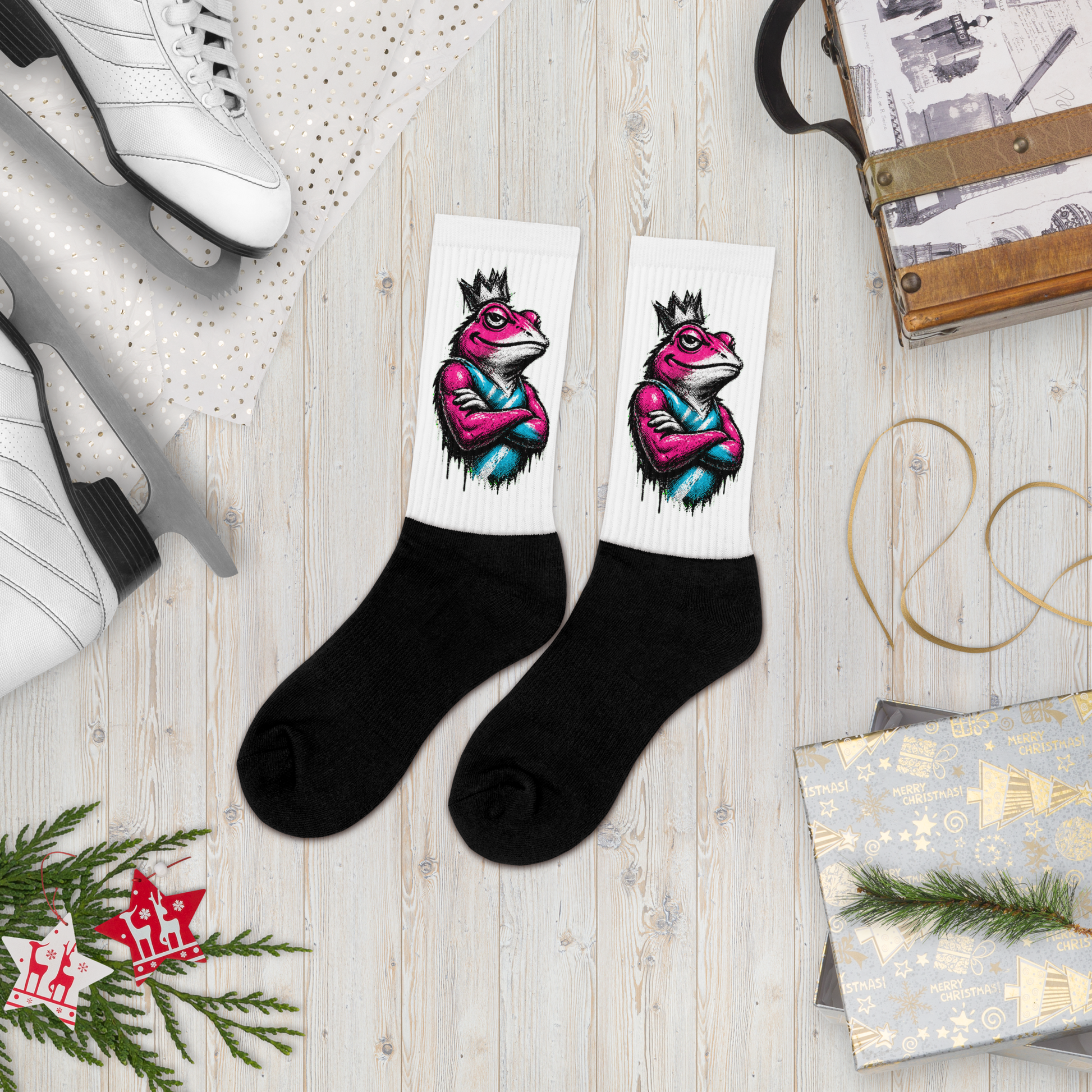 Black socks with colorful frog design on a wooden surface with shoes and gift boxes.