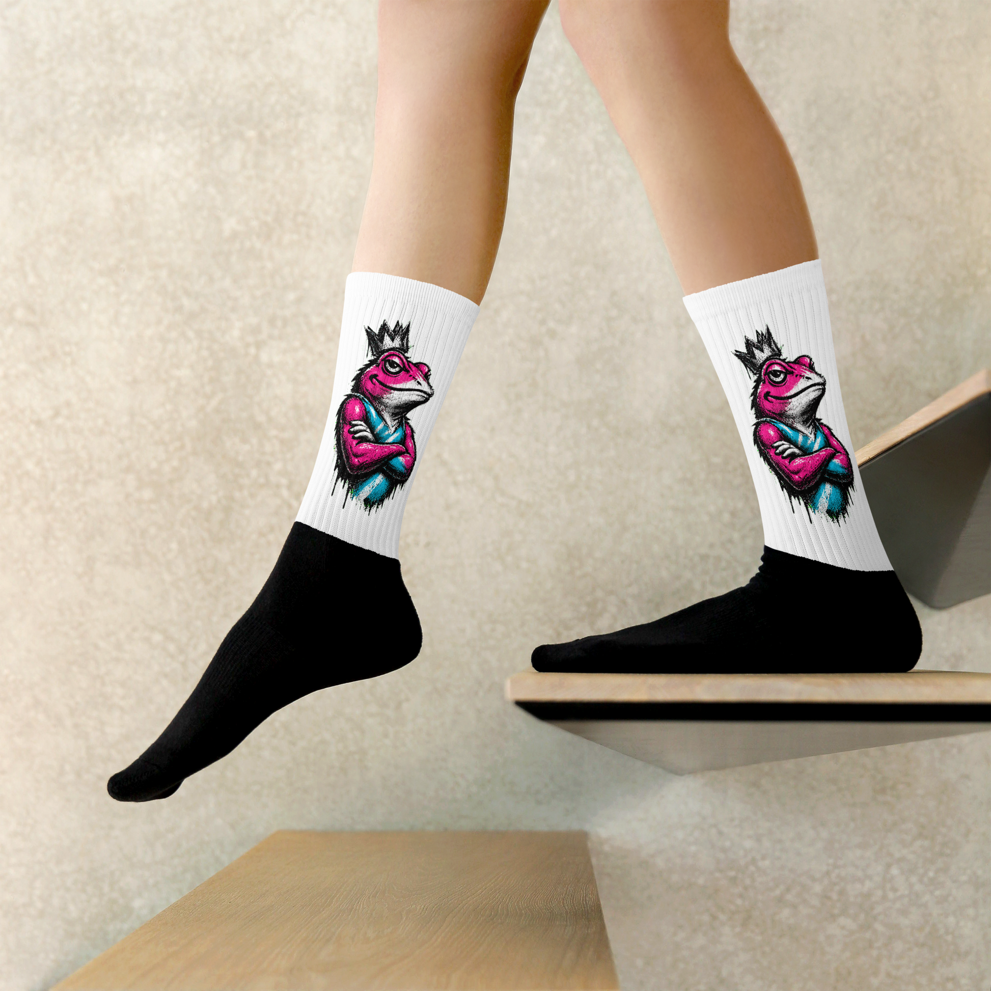 White socks with colorful frog design worn by a person on a neutral background