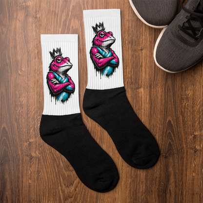 Pair of socks with a colorful frog design on a wooden surface
