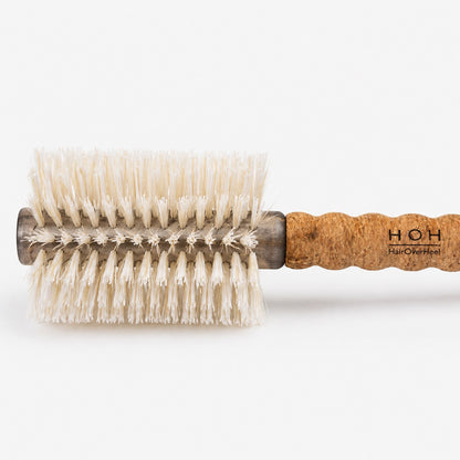 Round hairbrush with cork handle on a white background
