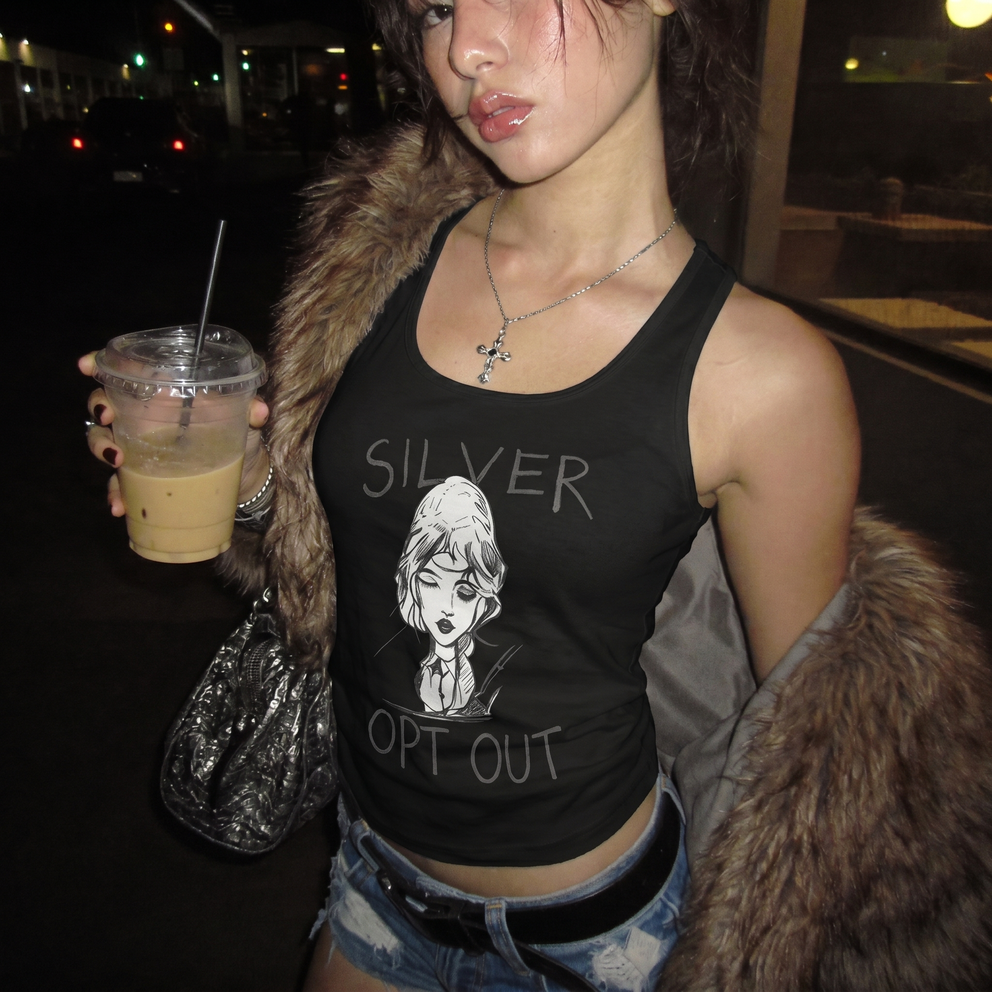 Woman wearing a black tank top with 'SILVER OPT OUT' text and graphic, holding a drink at night.