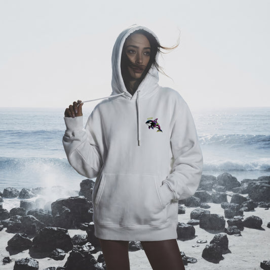 Person wearing a white hoodie with a logo on a rocky beach
