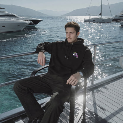 Man sitting on a boat deck with yachts and mountains in the background